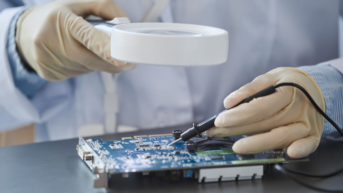 Engenheira inspecionando uma placa eletrônica com lupa