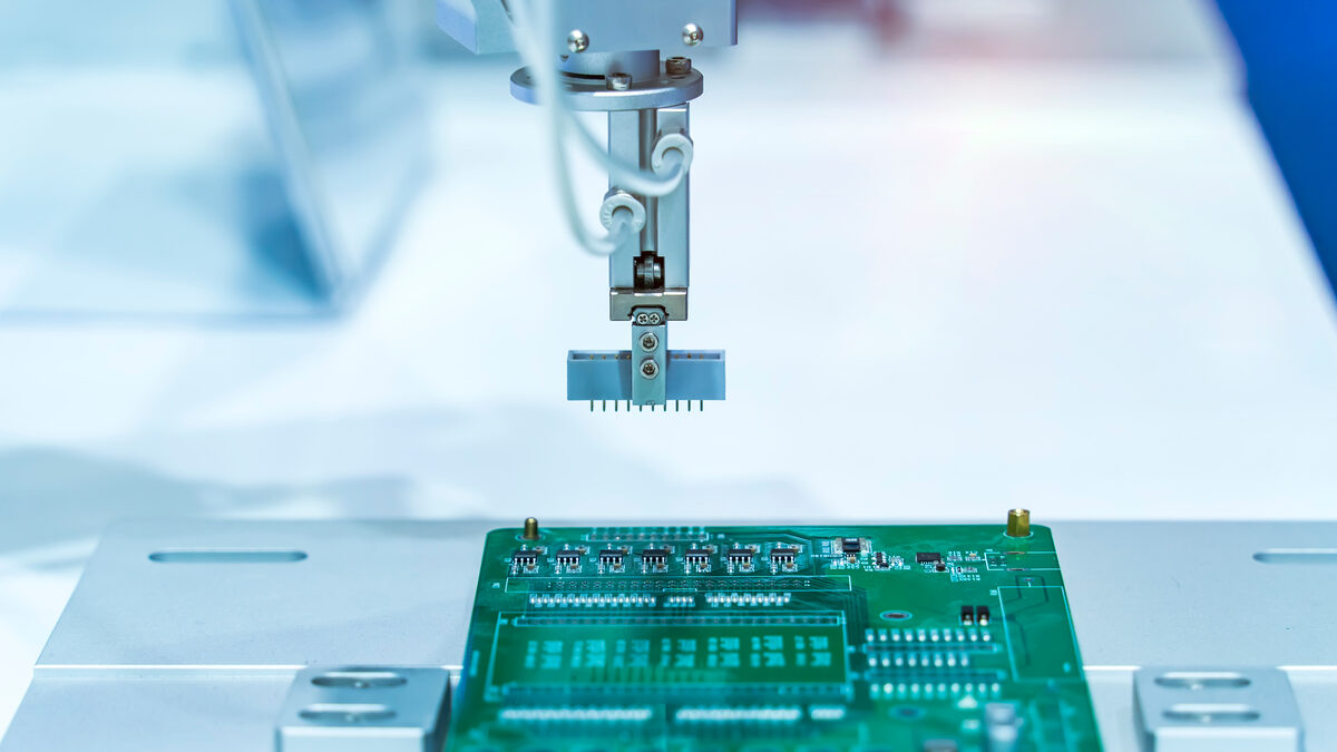 Equipamento de montagem automatizada posicionando componentes em placa de circuito impresso